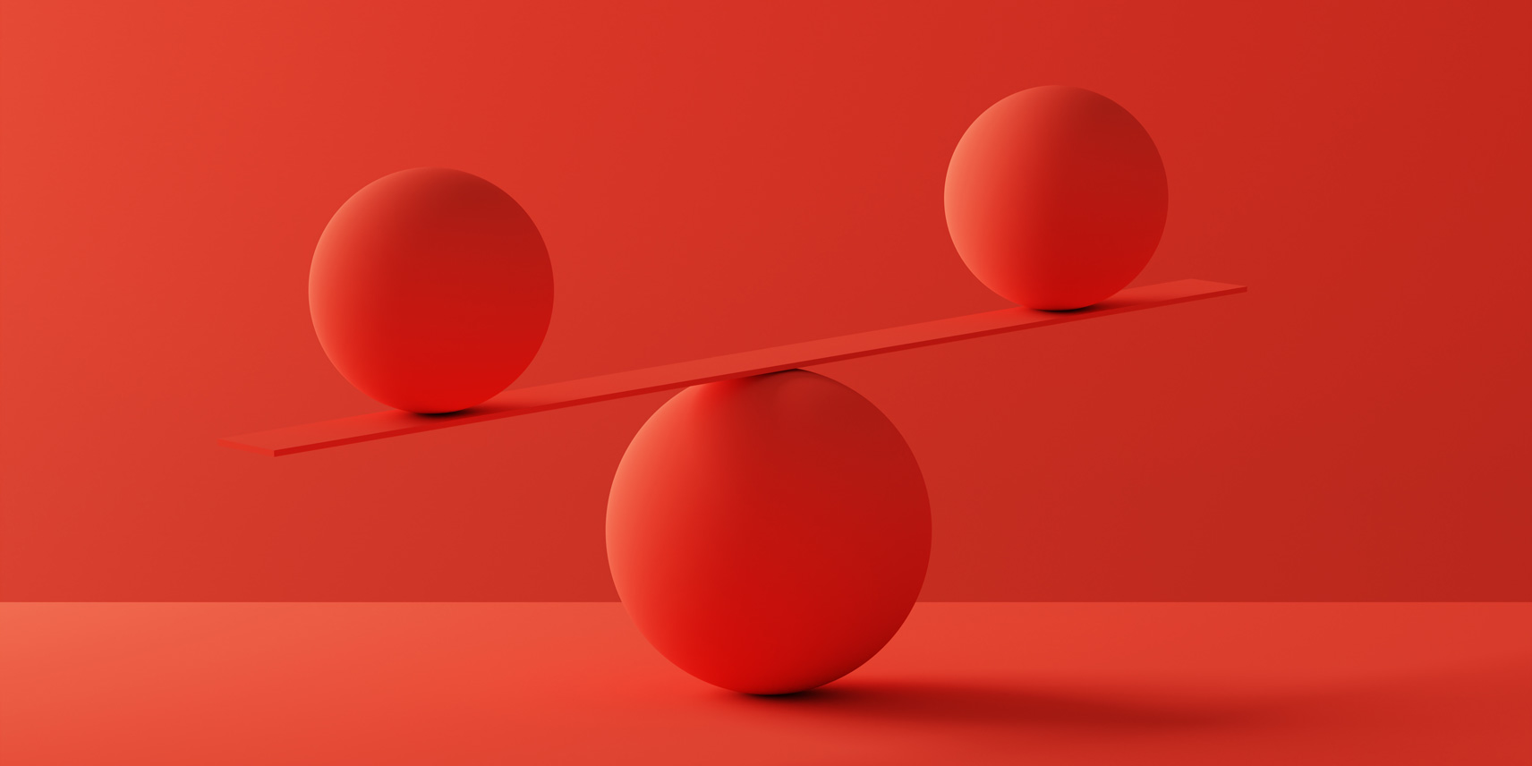 Red spheres balancing on a board.