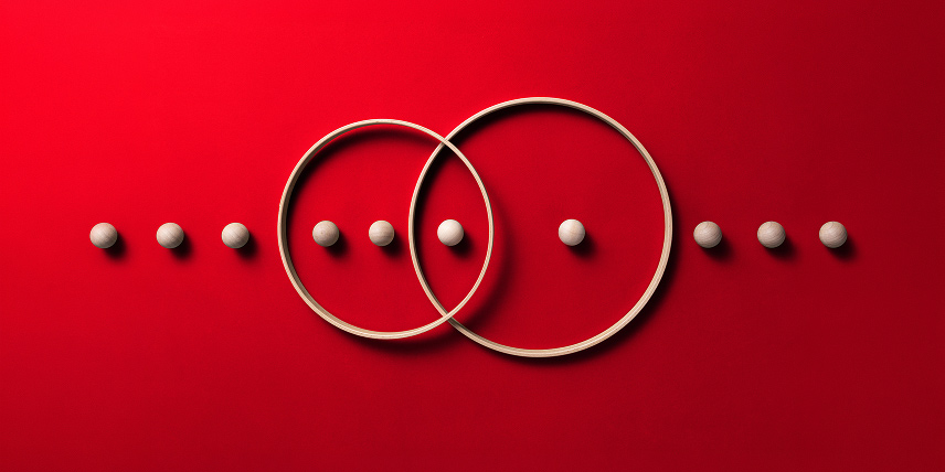 Overlapping wooden rings with a line of wooden balls on a red background