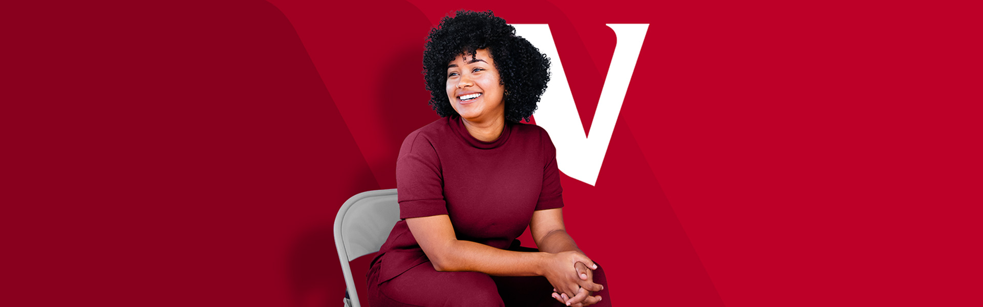 Woman sitting in chair smiling and looking out into the distance.