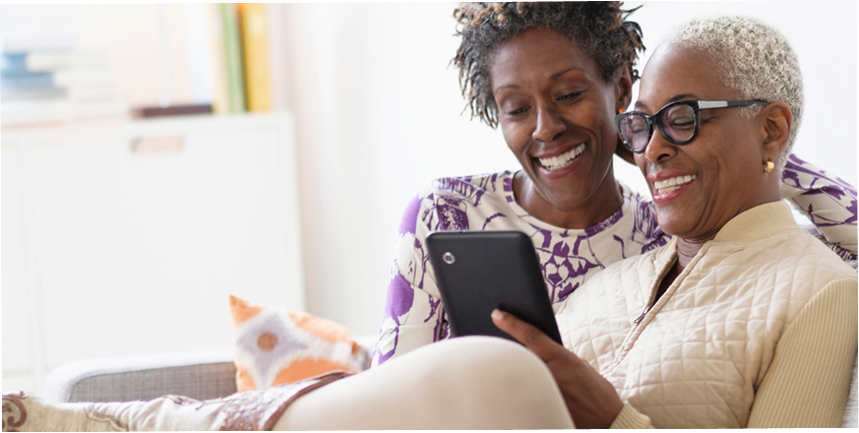  Women on couch looking at a tablet.