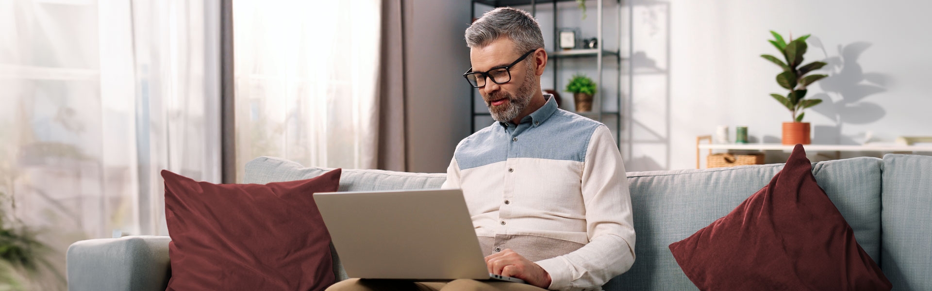 Investor sitting on a couch on a laptop converting an IRA to a Roth IRA with Vanguard. 