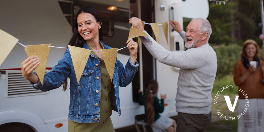 A family setting up decorations outside, laughing and smiling.