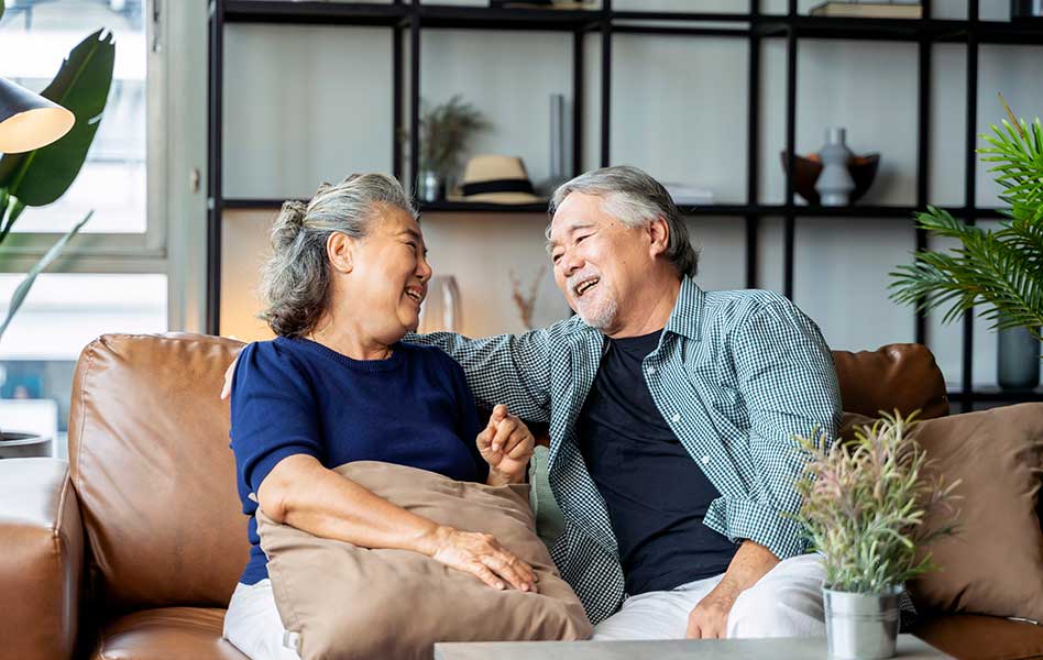 old senior asian retired age marry couple wellness lifesstyle together at home,old people laugh smile together with love and bonding on sofa in living room home interior background