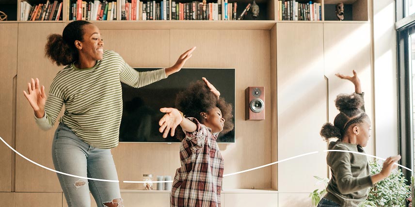 A mother dancing with her two children at home