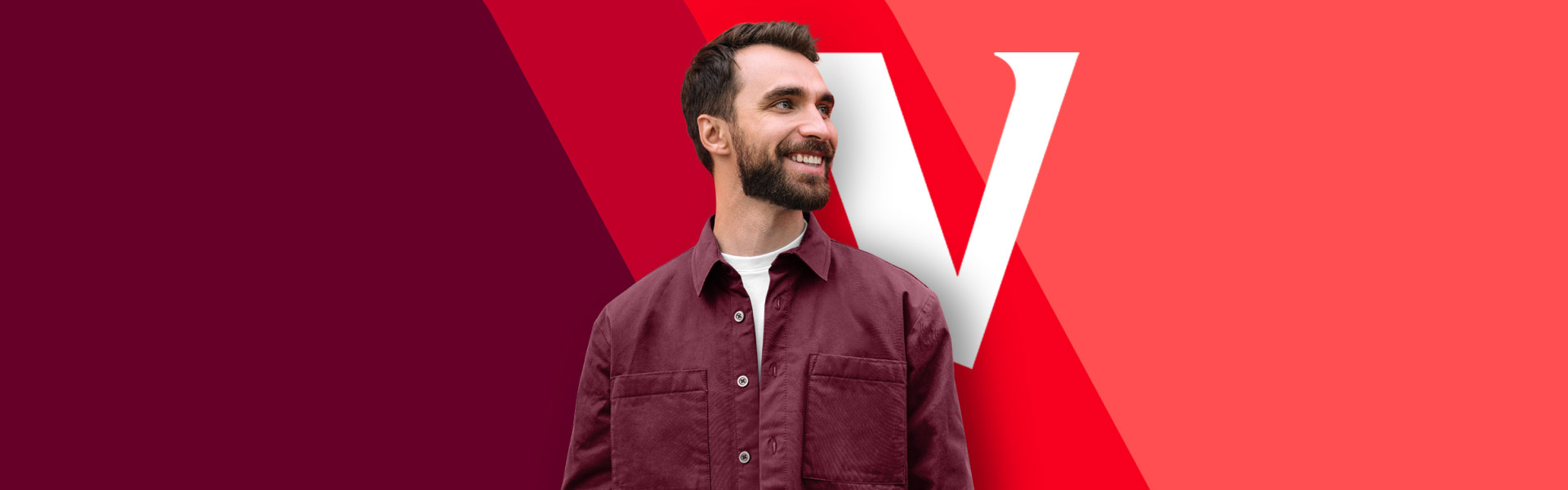 A man looks off to the side smiling with a Vanguard V logo visible in the background.