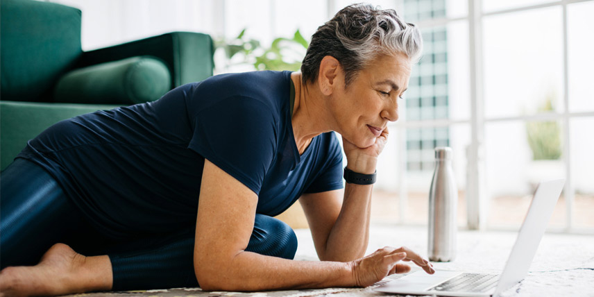 Woman laying on the floor using her laptop.