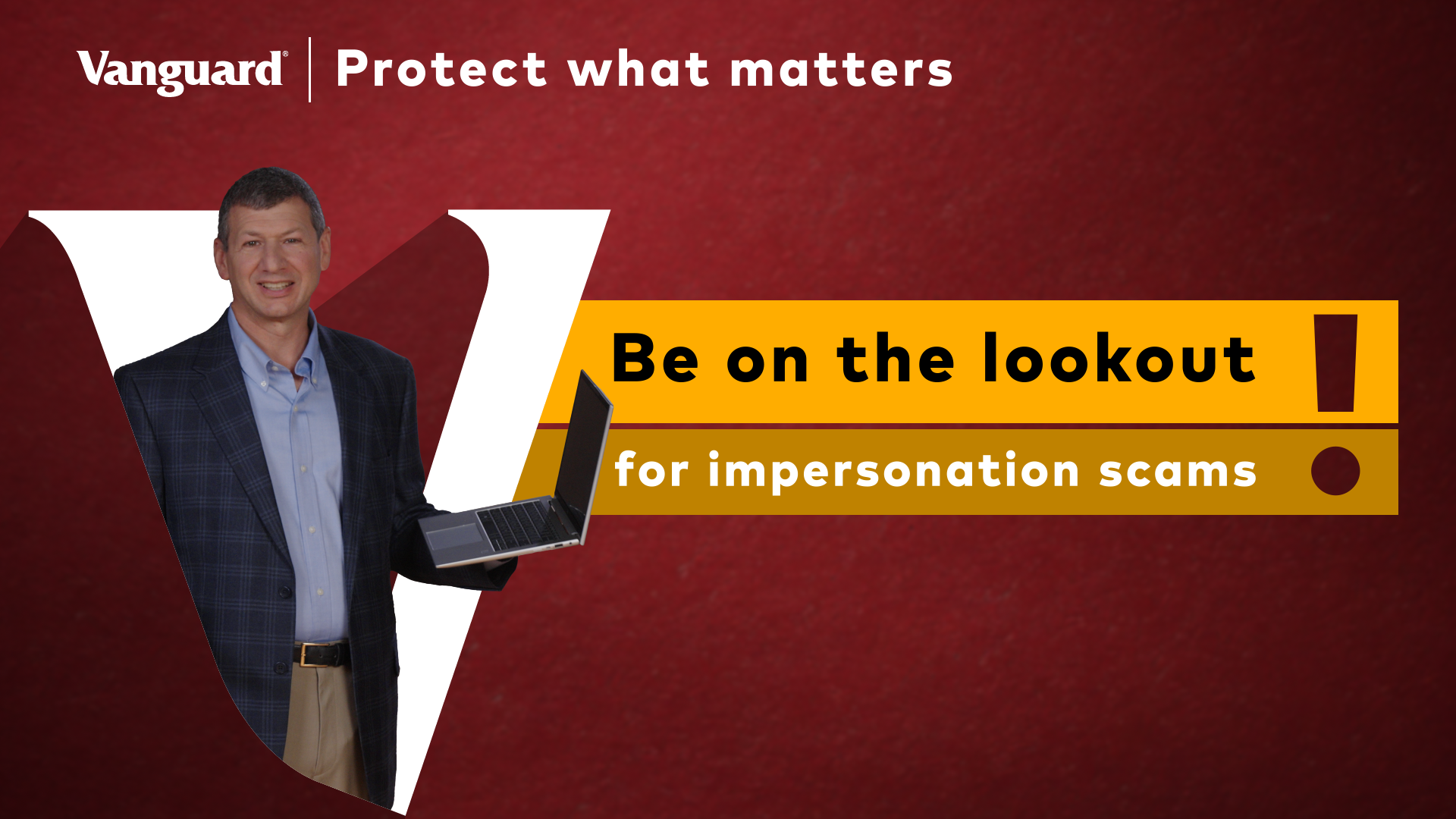 Video still of a man standing, while holding a laptop and speaking    about financial fraud in front of a large Vanguard "V" on a red background. 