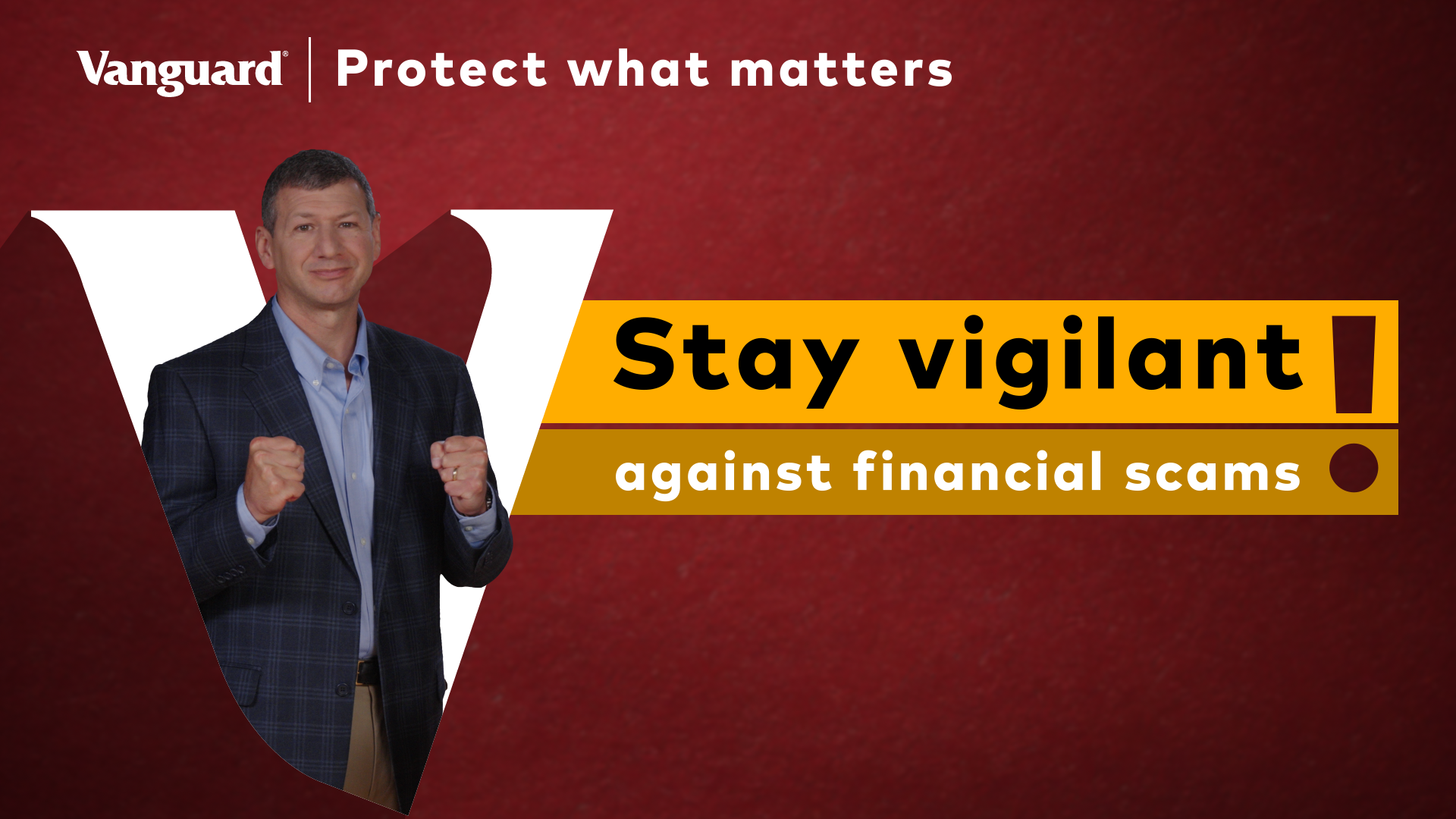 A video still showing a man in a suit standing in front of a large white Vanguard "V" on a red background with text reading “Protect what matters” and “Stay vigilant against financial scams.”