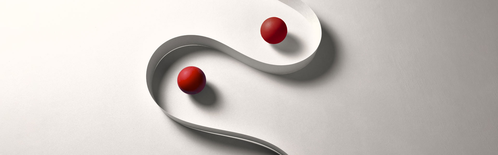 Two red spheres between curved white ribbon.