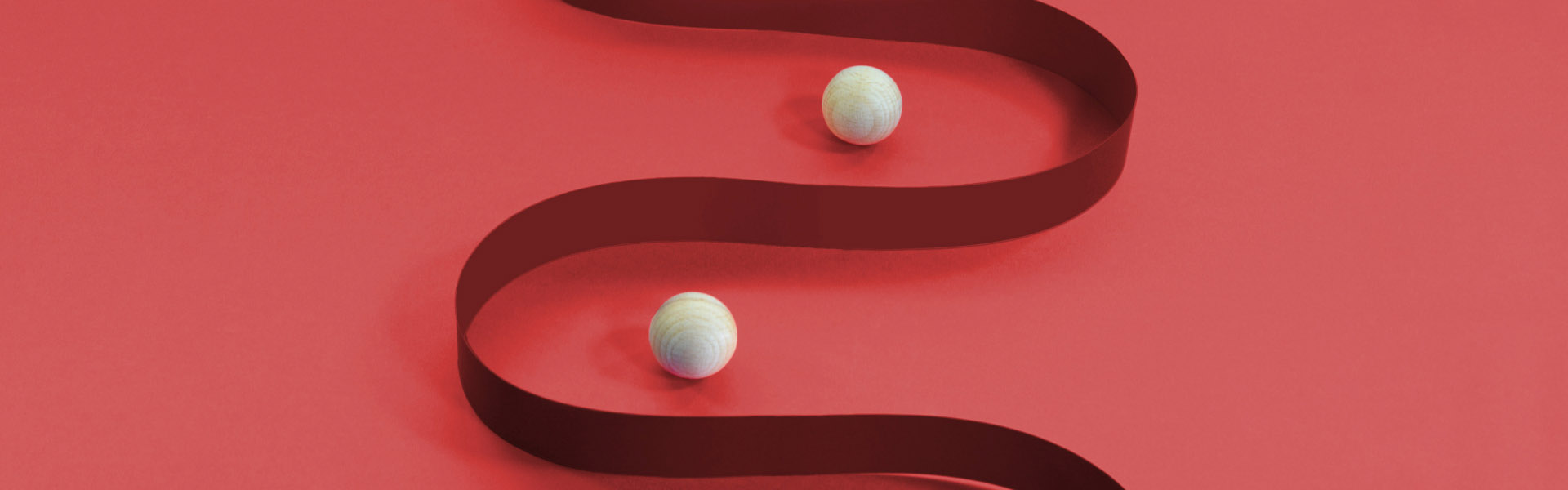 Wooden balls in between curved striped paper.