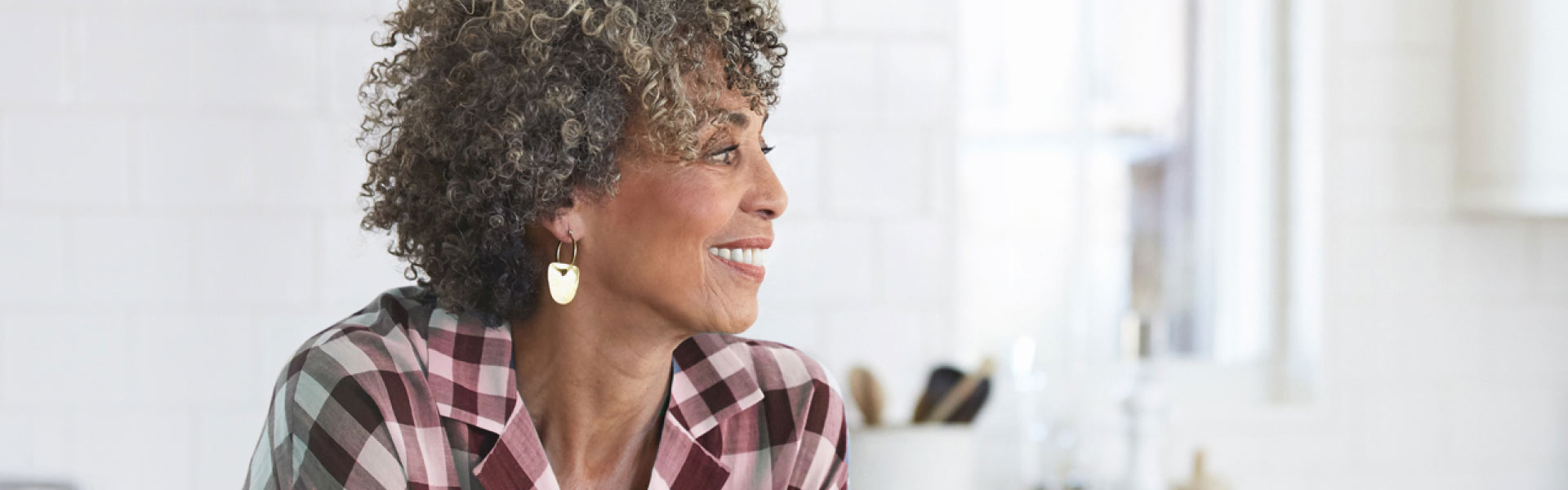 What alt-text should be used for A-Spot?	A curly-haired older woman, dressed in a plaid shirt, is in her kitchen smiling broadly as she looks over her left shoulder. 