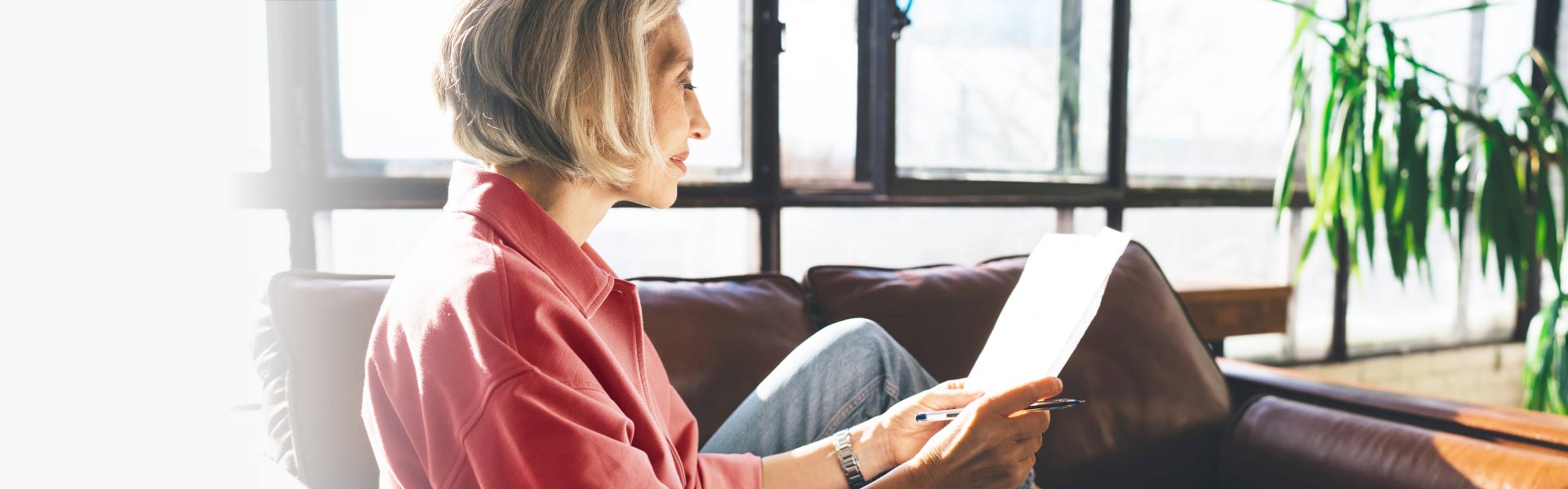  A woman sitting on a couch, looking at a list.