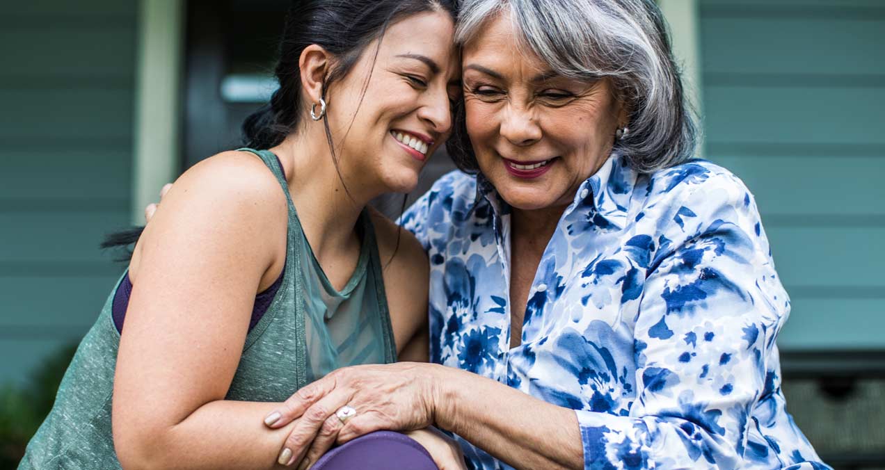 Two women sitting together outside.