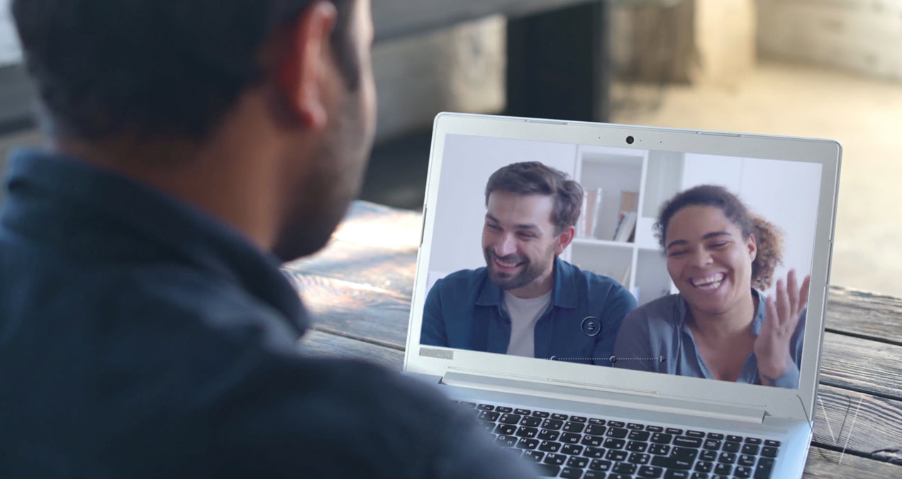 Man having a virtual call on his laptop with a happy couple.