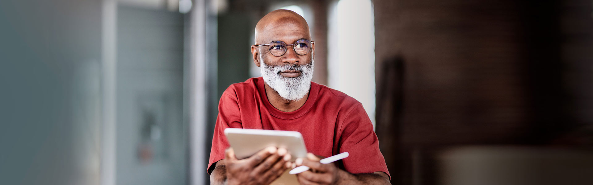 Bearded man in glasses faces forward with a confident gaze.