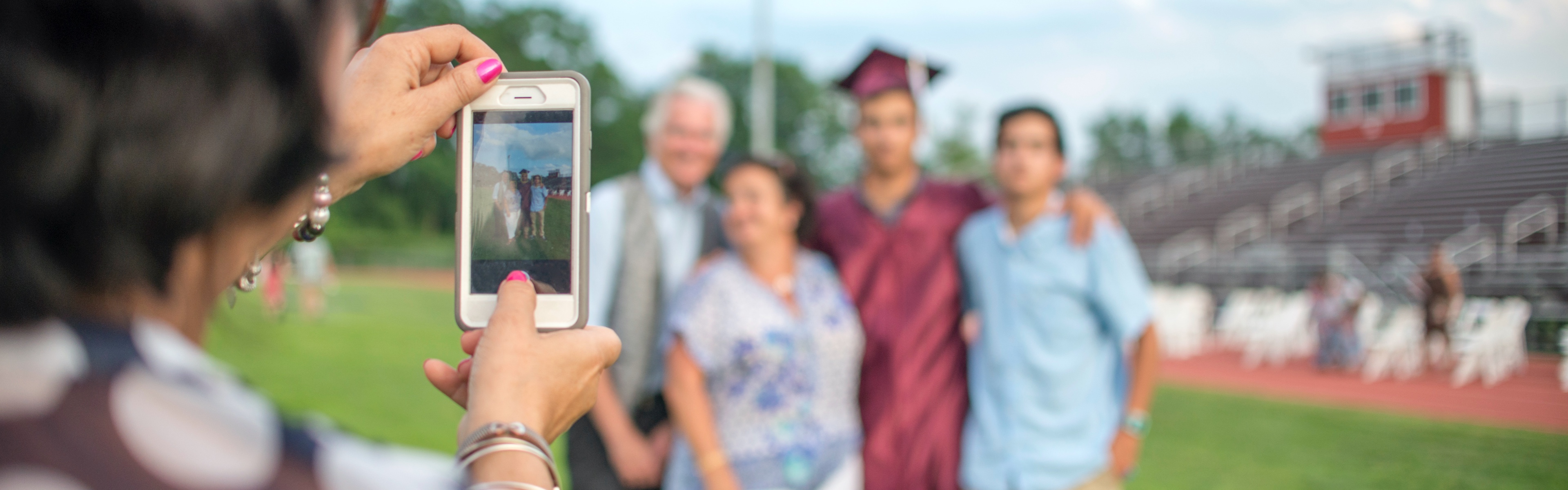 A family celebrating a graduation poses for a picture after the ceremony.