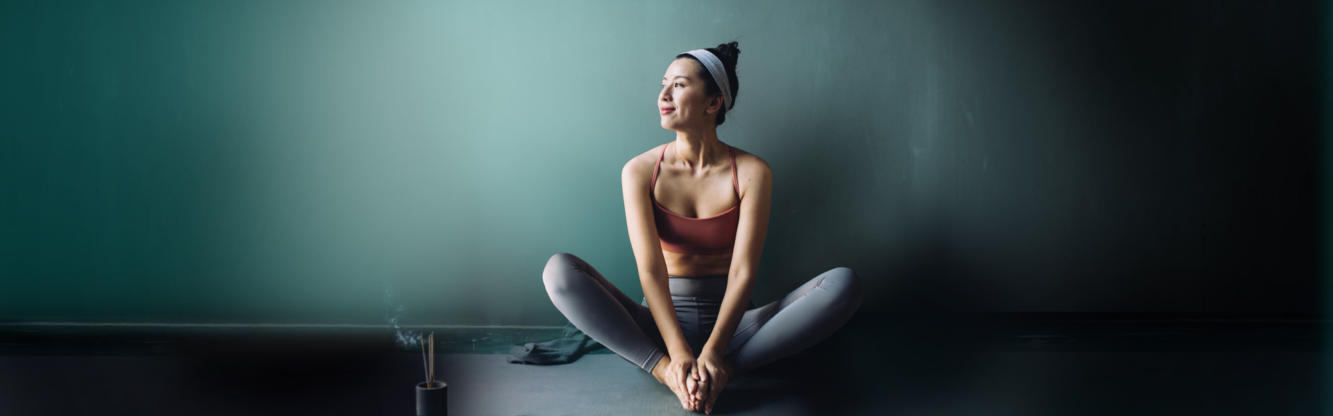 A woman sitting in a yoga position and smiling.