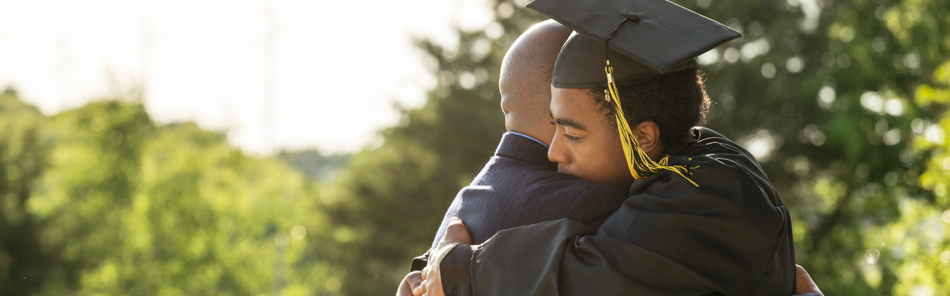 Dressed in his graduation cap and gown, a young man hugs his father and thanks him for the 529 plan that helped pay for his college education.