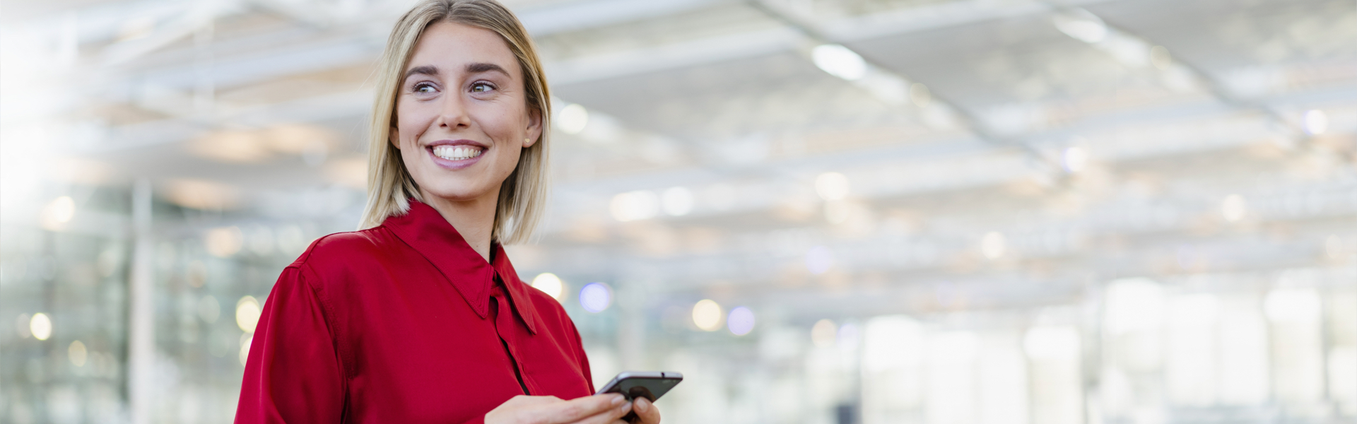 A young woman is smiling into the distance.