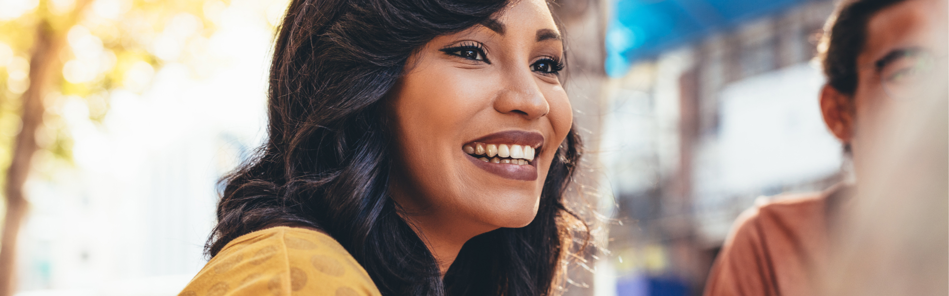 A young woman is smiling at someone out of the frame.