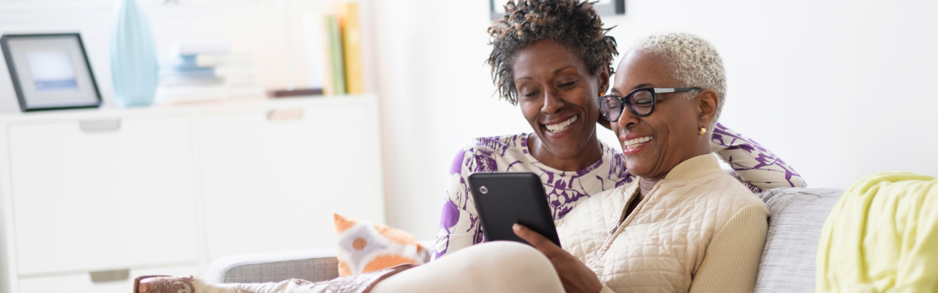 Two women are sharing a tablet.