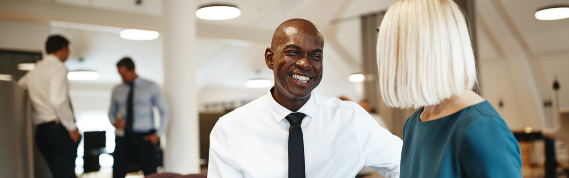 A man in an office is smiling at his coworker.