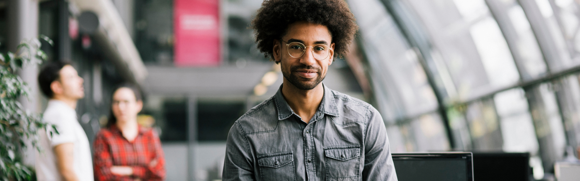 A young man is looking straight forward into the camera.