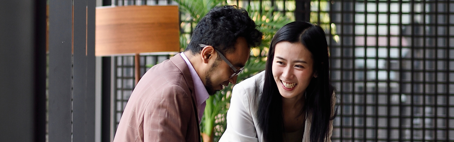 A woman and man are looking at paperwork on a table.