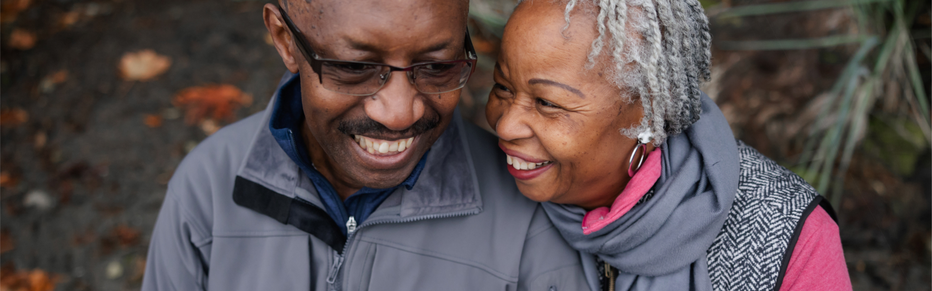 Retired couple, walking closely together. 