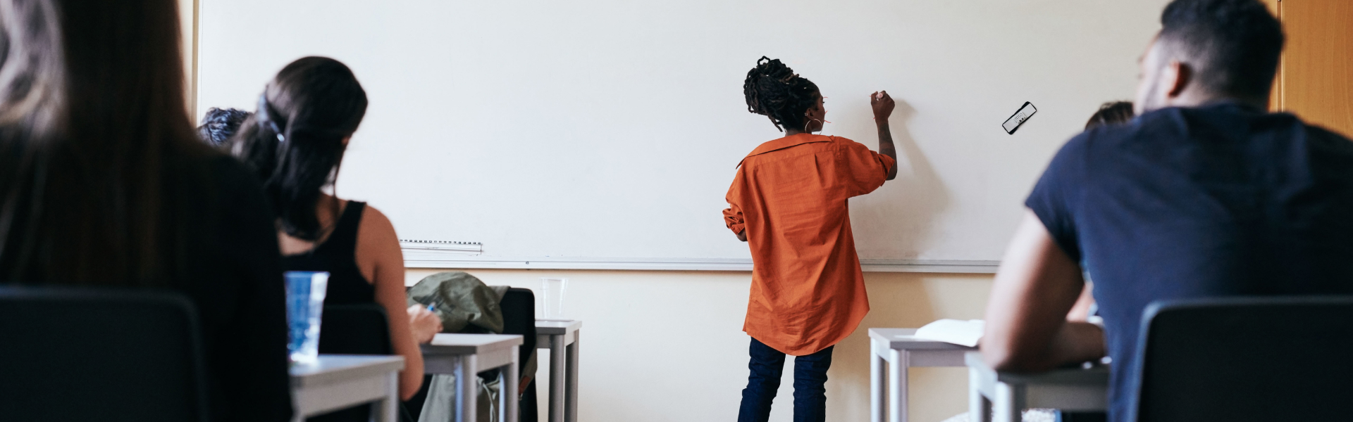 A girl is writing on a whiteboard.