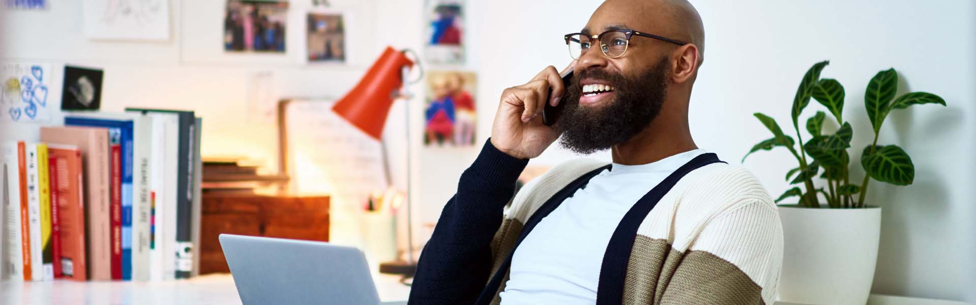 Cheerful businessman working from home on phone