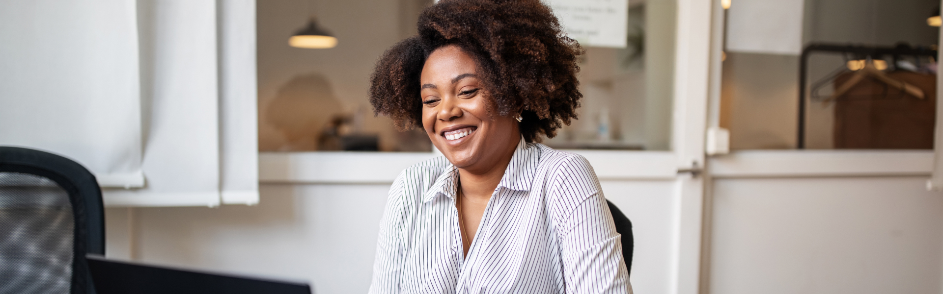 Woman with pleasant look on her face sitting in front of laptop.	