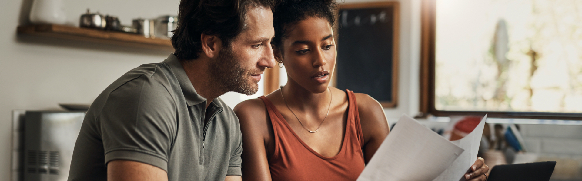 A man and a woman are reviewing paperwork together.