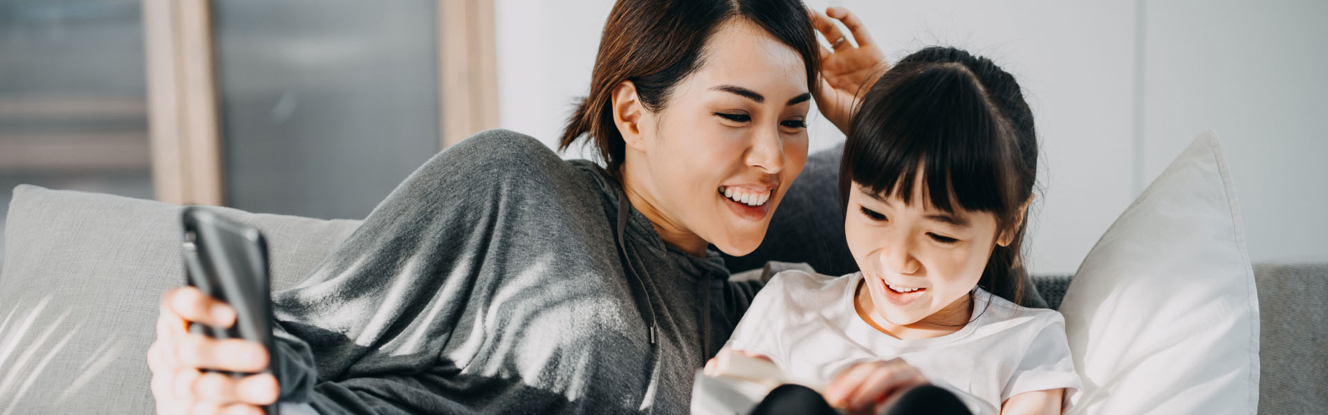 A young woman and a girl are smiling.