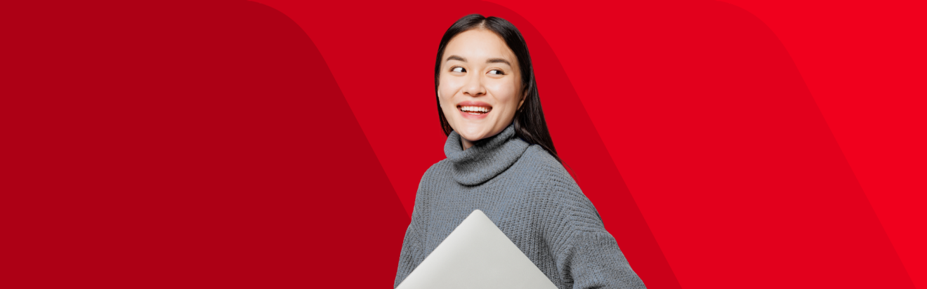 A woman smiling and standing in front of a red background