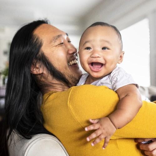 Adult and child smiling and sharing a loving moment.
