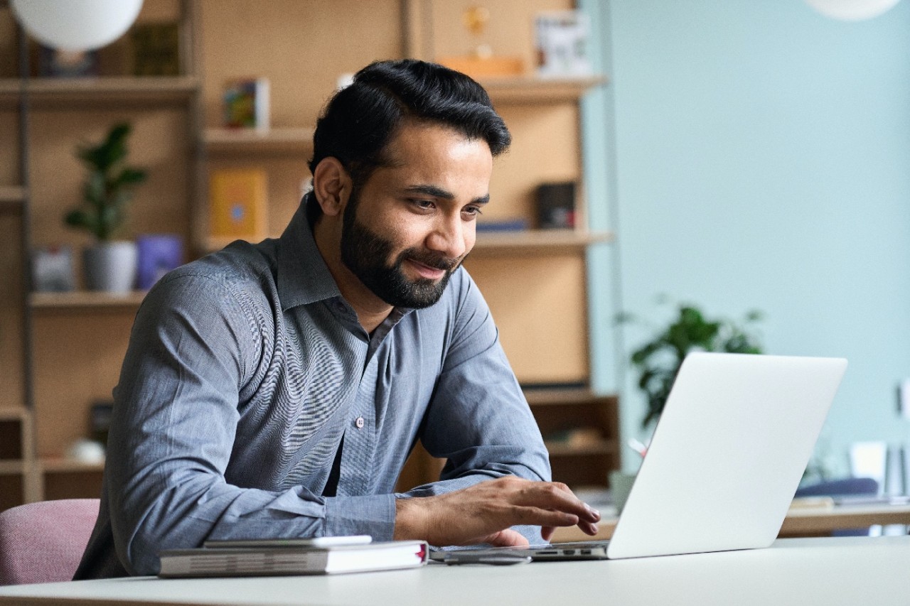  A young man is happily working on his laptop.