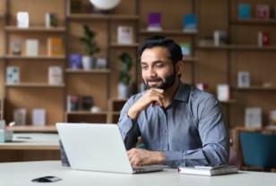 A man is doing research on a laptop.