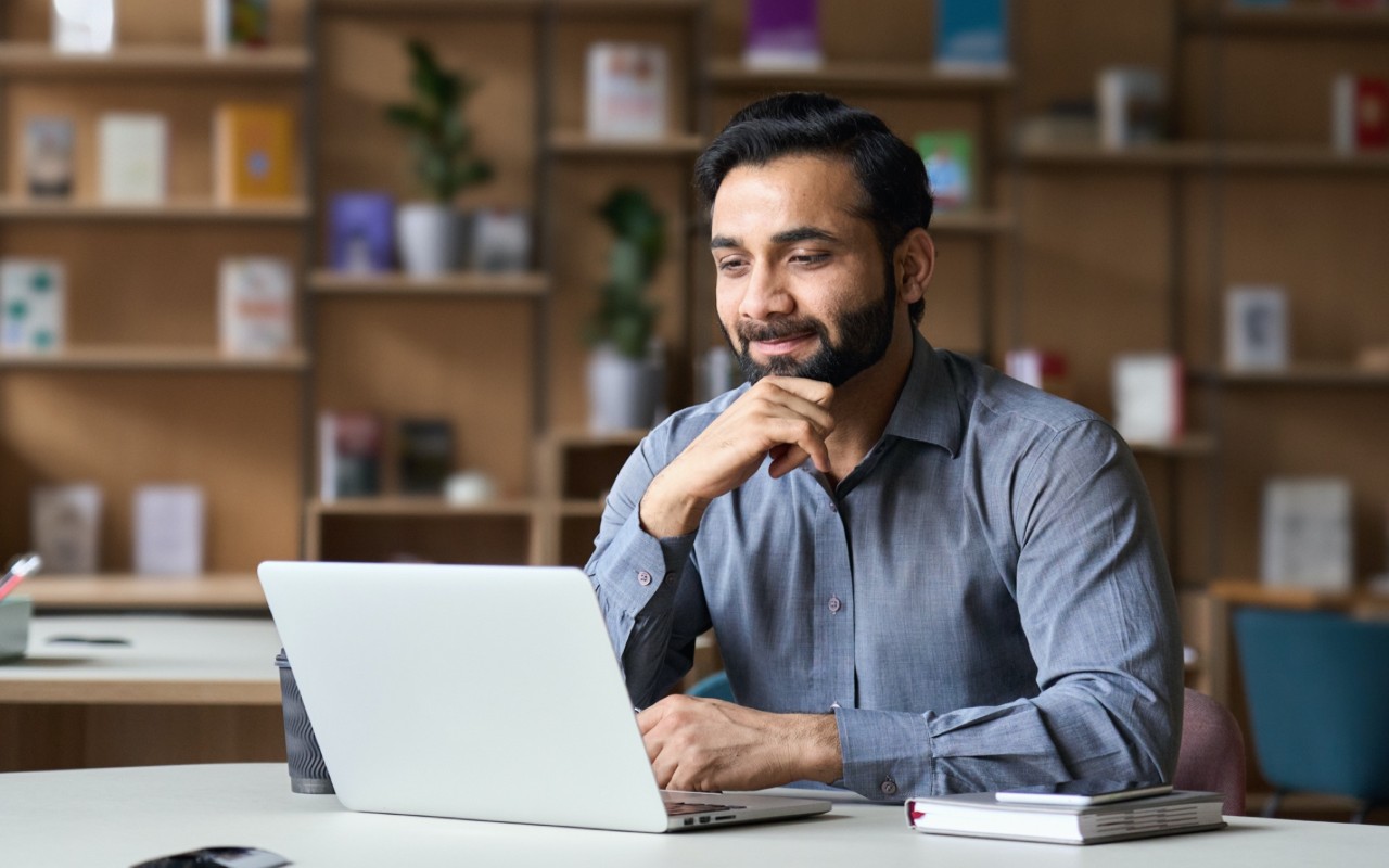 A man is doing research on a laptop.