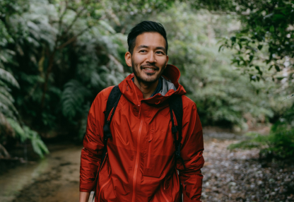 Man hiking in park surrounded by trees and plants.