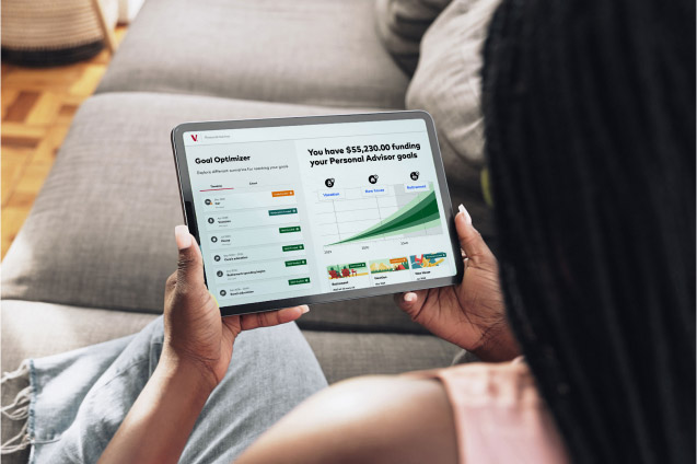 A woman sits on her couch while looking at her Personal Advisor dashboard.