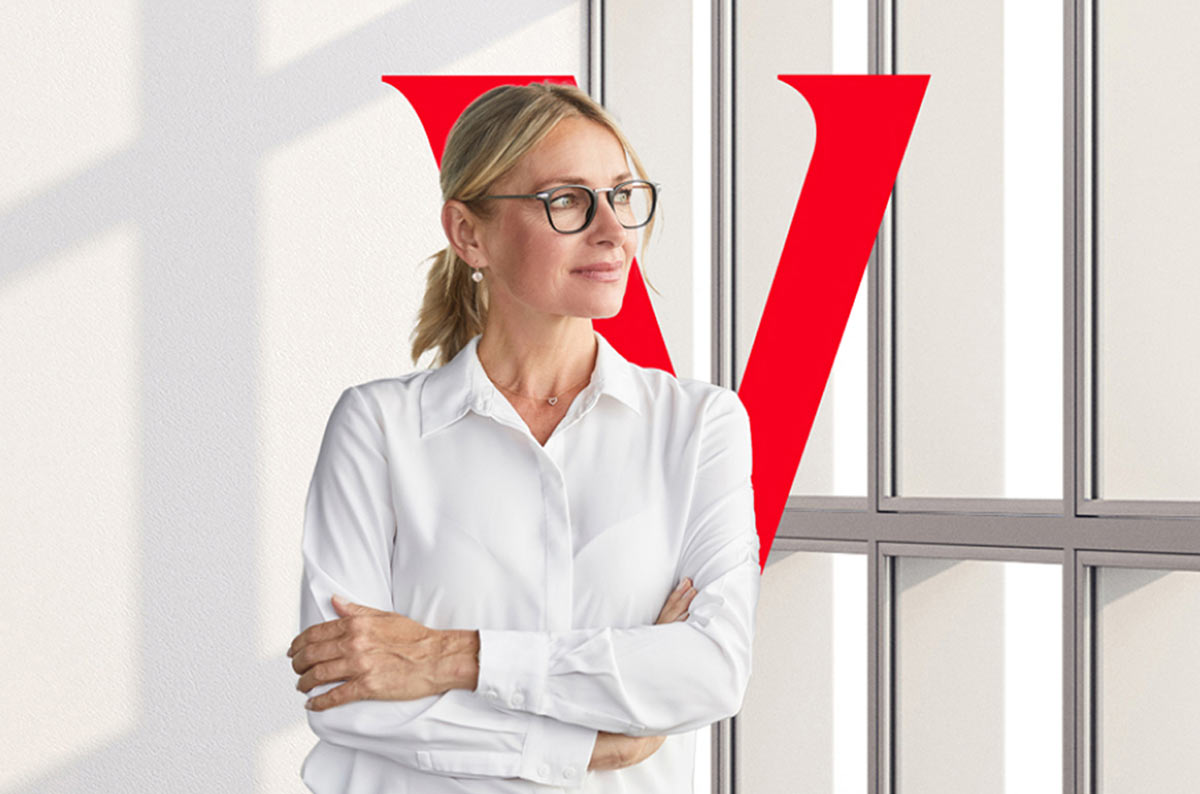 A woman in glasses looks toward a window with the Vanguard V behind her.