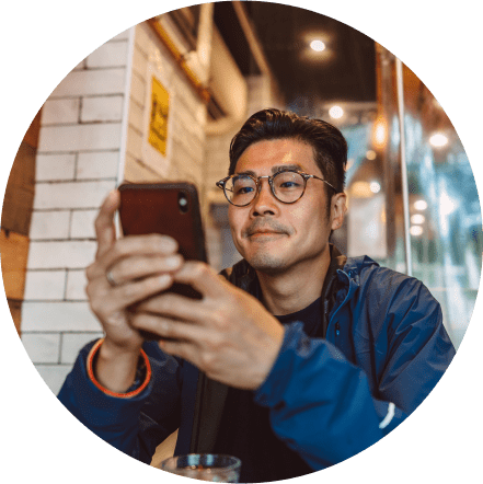 Man sitting at a table, looking at his phone.