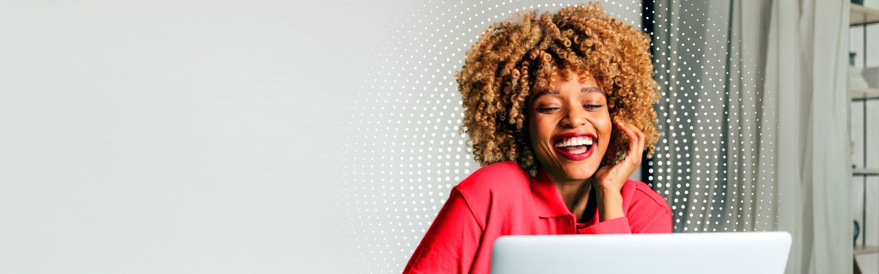 A young woman is researching how to invest with Vanguard on her laptop.