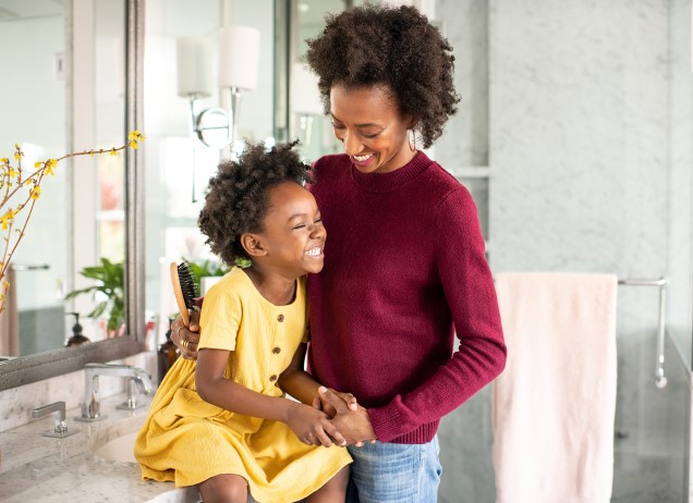 A parent and child smiling and embracing.