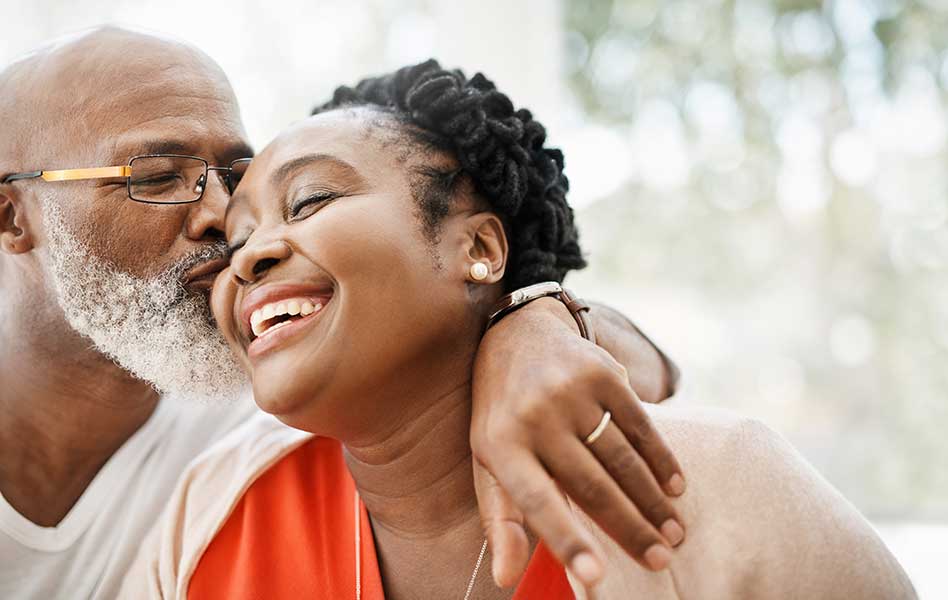 Man kissing his wife on the cheek.