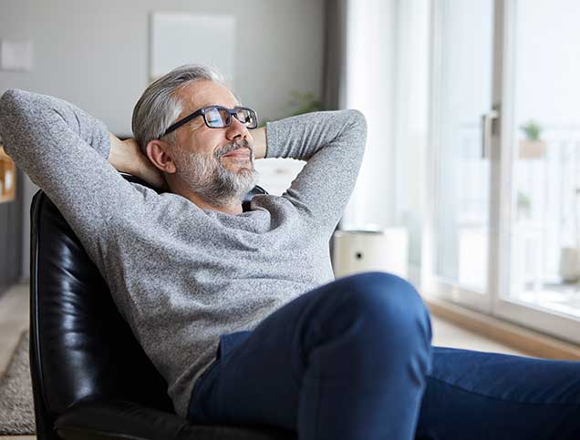 Man relaxing with his arms behind his head.
