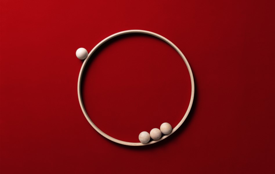 An image of spheres in a large ring on a red background.