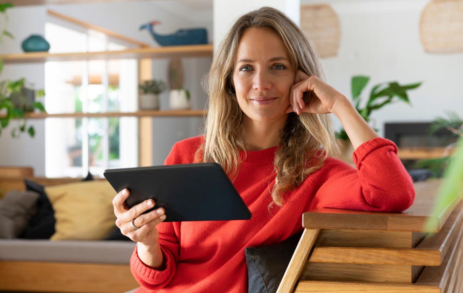 A young woman is using a tablet to learn about investing.