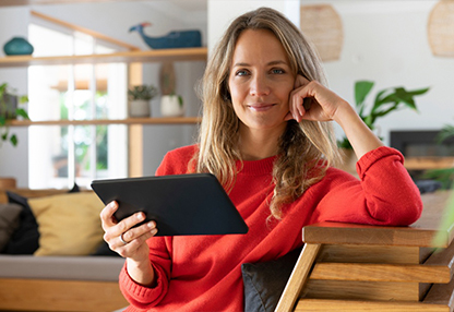 A young woman is using a tablet to learn about investing.